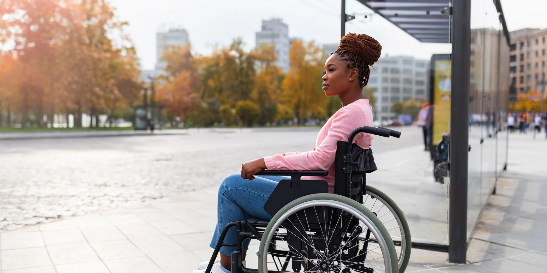 A wheelchair user waiting at a Sydney transit stop, ready for her Captain Taxis pickup